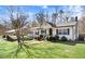 View of home showcasing maintained lawn, covered carport, and mature tree at 2246 Arrowhead Rd, Dunn, NC 28334