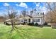 View of home showcasing maintained lawn, covered carport, and mature tree at 2246 Arrowhead Rd, Dunn, NC 28334