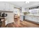 Charming kitchen featuring white cabinets, wood floors, and stainless steel dishwasher at 2246 Arrowhead Rd, Dunn, NC 28334