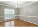 Light-filled dining room with hardwood floors, chair rail, and a modern chandelier at 2301 Lemuel Dr, Raleigh, NC 27615