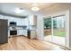 Bright kitchen with white cabinets, stainless steel appliances, hardwood floors, and a sliding glass door to the deck at 2301 Lemuel Dr, Raleigh, NC 27615