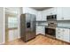 Modern kitchen with stainless steel appliances, white cabinets, and beautiful tile backsplash at 2301 Lemuel Dr, Raleigh, NC 27615