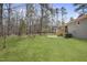Large backyard with lush lawn, mature trees, and side view of home's exterior at 2312 Valley Rd, Sanford, NC 27330
