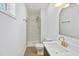 Bright bathroom featuring white marble shower, light wood floor, and brass fixtures at 2312 Valley Rd, Sanford, NC 27330