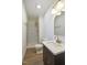 Bright bathroom featuring white marble shower, light wood floor, and brass fixtures at 2312 Valley Rd, Sanford, NC 27330