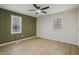 This bedroom showcases lots of space, a modern ceiling fan, and an accent wall at 2312 Valley Rd, Sanford, NC 27330