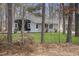 Quaint one-story home with light grey painted brick, offering a peaceful wooded view at 2312 Valley Rd, Sanford, NC 27330