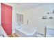 Bathroom featuring a white soaking tub and a red door at 2313 Prince St, Durham, NC 27707