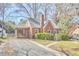 Charming brick home with a screened-in porch, manicured landscaping, and a gravel driveway at 2313 Prince St, Durham, NC 27707