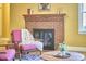 Cozy living room with brick fireplace, pink accent chair, and hardwood floors at 2313 Prince St, Durham, NC 27707