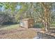 View of shed in the backyard with exterior work area and tree shaded patio at 2313 Prince St, Durham, NC 27707