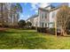 A lush backyard featuring a manicured lawn, privacy landscaping, and patio seating with an umbrella at 233 Candia Ln, Cary, NC 27519