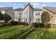 A lush backyard featuring a manicured lawn, privacy landscaping, and patio seating with an umbrella at 233 Candia Ln, Cary, NC 27519