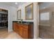 Well-appointed bathroom features dual sinks, wood cabinets, granite counters, framed mirrors, and a glass door shower at 233 Candia Ln, Cary, NC 27519