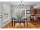 This dining area showcases a wood table with a bench, hardwood floors, natural light, and flows into the kitchen with counter seating at 233 Candia Ln, Cary, NC 27519