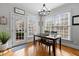 Bright dining room features a wood table with a bench, chair seating, hardwood floors, and natural light from two windows at 233 Candia Ln, Cary, NC 27519