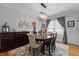 Elegant dining room features a wooden buffet, oval dining table, patterned rug, chandelier, and natural light from the window at 233 Candia Ln, Cary, NC 27519