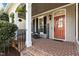 Cozy front porch with brick flooring, classic rocking chair, and a welcoming entryway at 233 Candia Ln, Cary, NC 27519