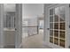 Hallway with carpet flooring, leading to an open area with natural light, and a staircase behind a glass door at 233 Candia Ln, Cary, NC 27519