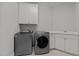 Laundry room with washer, dryer, utility sink, white cabinets, and tiled flooring at 233 Candia Ln, Cary, NC 27519