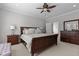 Inviting main bedroom with wood furniture, a neutral carpet, and a door leading to an ensuite bathroom with a soaking tub at 233 Candia Ln, Cary, NC 27519
