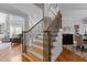 Elegant staircase with wood treads, decorative iron railings, and abundant natural light at 233 Candia Ln, Cary, NC 27519