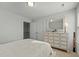 Bright bedroom showcasing a dresser with a stylish mirror, and sunlight pouring through the window at 234 Macallan Dr, Burlington, NC 27215