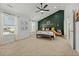 Main bedroom features a dark green accent wall, bench seat, and a black ceiling fan at 234 Macallan Dr, Burlington, NC 27215