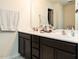 Bathroom featuring double sink vanity with dark wood cabinets, bright lighting and ample counter space at 2575 Sheriff Watson Rd, Sanford, NC 27332