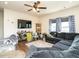 Cozy living room with a ceiling fan, mounted TV, blue patterned curtains, and comfortable gray couches at 2575 Sheriff Watson Rd, Sanford, NC 27332