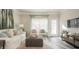 Bright living room featuring a white sofa, patterned chairs, ottoman, and decor at 274 Deodora Ln, Cameron, NC 28326