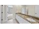 Bright bathroom featuring a granite countertop vanity, and sinks, and a neutral color palette at 2803 Cameron Pond Dr, Cary, NC 27519