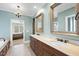 This bathroom features dual sinks, wooden cabinets, decorative mirrors, and a doorway leading to the bedroom at 2803 Cameron Pond Dr, Cary, NC 27519