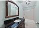 Bathroom featuring dark wood vanity with granite countertop and decorative framed mirror at 2803 Cameron Pond Dr, Cary, NC 27519