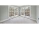 Bright, empty bedroom with light-colored carpet and two large windows at 2803 Cameron Pond Dr, Cary, NC 27519