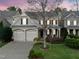 Inviting two-story home featuring a manicured front yard, attached two-car garage, and a charming covered front porch at 2803 Cameron Pond Dr, Cary, NC 27519