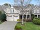 Inviting two-story home featuring a manicured front yard, attached two-car garage, and a charming covered front porch at 2803 Cameron Pond Dr, Cary, NC 27519