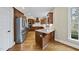 Open kitchen with an island, granite countertops, custom cabinetry, and modern appliances at 2803 Cameron Pond Dr, Cary, NC 27519