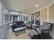 Screened-in back porch with comfortable seating, ceiling fan, and beadboard ceiling at 2803 Cameron Pond Dr, Cary, NC 27519