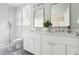 Modern bathroom featuring dual sinks, sleek countertops, a glass-enclosed shower, and elegant fixtures at 2816 Cascadilla St, Durham, NC 27704