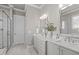 Modern bathroom featuring double sinks, white marble, and a glass shower at 2826 Walden Rd, Apex, NC 27502