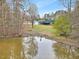 View of the pond, home and garage, with reflection in the water at 3121 Tarheel Clubhouse Rd, Raleigh, NC 27604