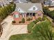Stunning aerial view showcasing the brick home, manicured landscaping, and spacious driveway at 3204 Cobblestone Ct, Raleigh, NC 27607