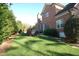 Beautiful backyard featuring a brick house, lush lawn, and privacy landscaping at 3204 Cobblestone Ct, Raleigh, NC 27607