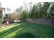 Well-maintained backyard with lush grass, privacy fence, and a patio area with black metal railing at 3204 Cobblestone Ct, Raleigh, NC 27607