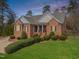 Charming brick home with a manicured lawn and inviting front porch, perfect for relaxation at 3204 Cobblestone Ct, Raleigh, NC 27607