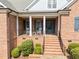Charming brick home featuring a welcoming front porch with rocking chairs and a well-manicured lawn at 3204 Cobblestone Ct, Raleigh, NC 27607