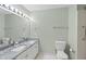 Bathroom featuring double sinks, large mirror with vanity lights and walk-in shower at 3312 Clandon Park Dr, Raleigh, NC 27613