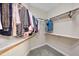 Walk-in closet with hanging clothes on wooden rods and shelving at 3312 Clandon Park Dr, Raleigh, NC 27613