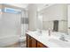 Bright bathroom featuring double sinks, a large mirror, and a shower-tub combination with a stylish curtain at 3609 Kilgo Dr, Durham, NC 27705